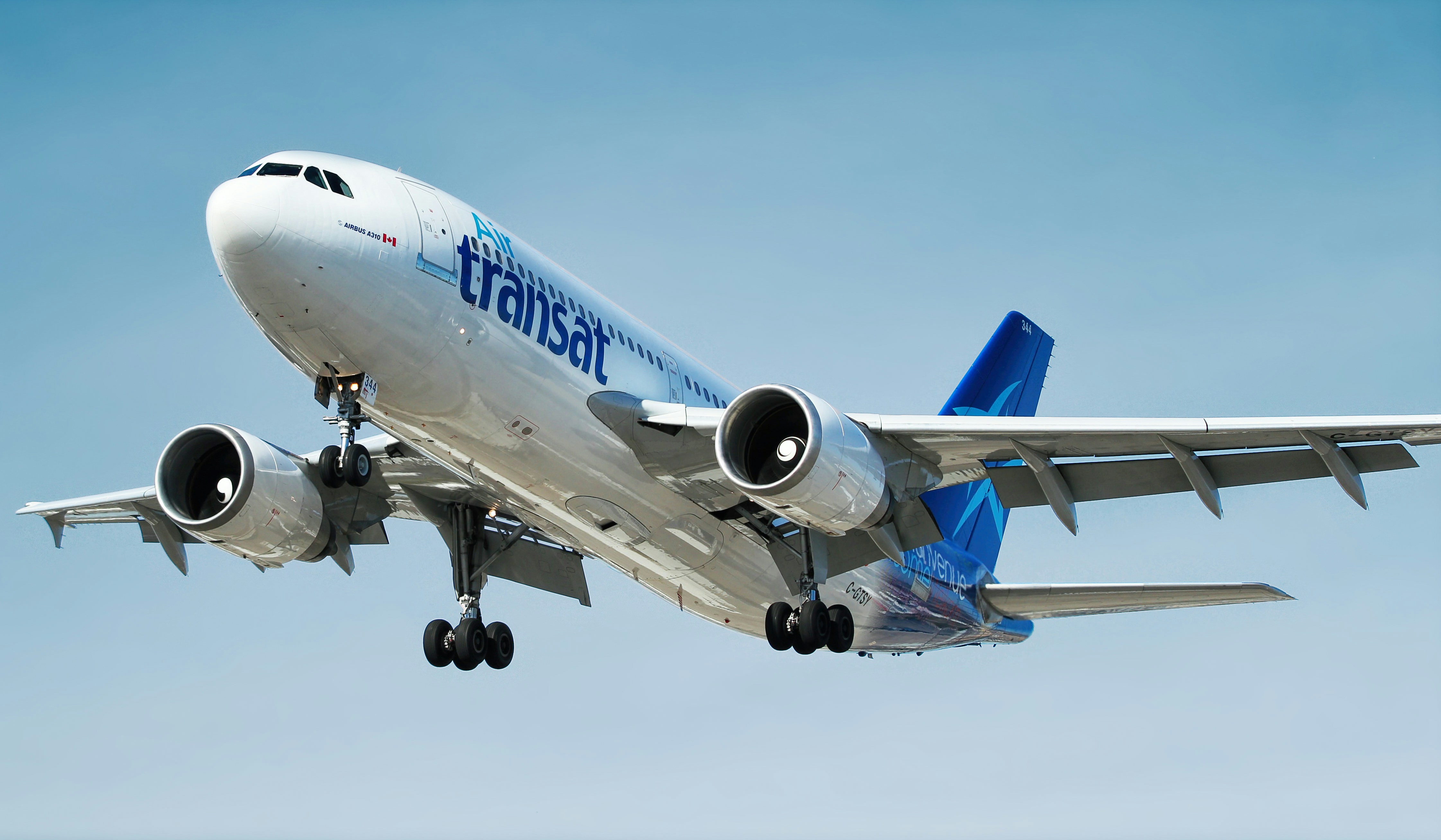 Air Transat airplane flying in a clear blue sky